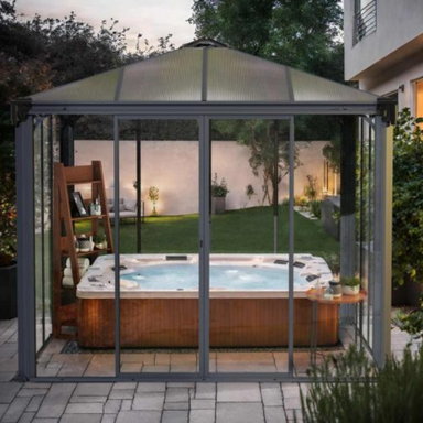 The Palram Ledro 3000 enclosed gazebo being used as a hot tub cover on a patio in a modern style garden.
