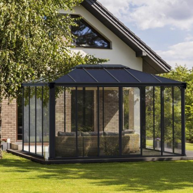 The Palram Ledro 4300 enclosed gazebo on the patio in a sunny garden setting next to a modern house.