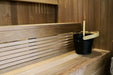 Black bucket with a wooden handle on a wooden bench in a sauna