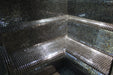 Mosaic tiled bench in a dimly lit steam room