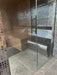 Glass-enclosed steam room with mosaic tile walls and floor.