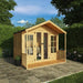 A front-right side view of the Mercia Wessex 8x8 foot summerhouse in a sunny garden setting with lots of greenery.