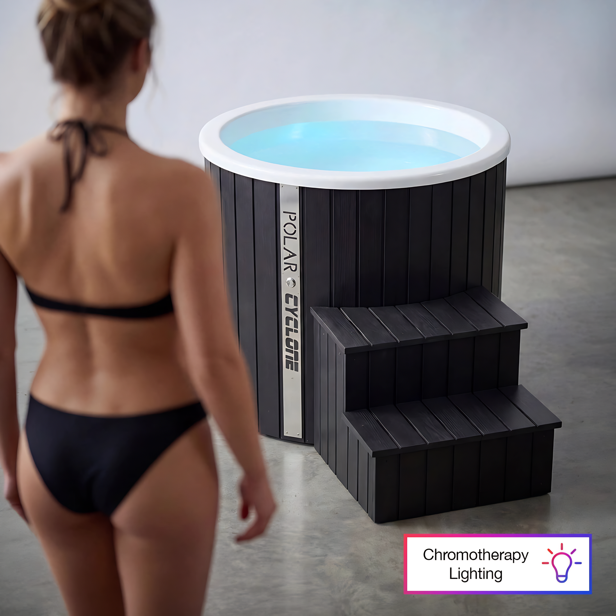 Polar Recovery Cyclone wooden ice bath in black, chromotherapy lighting with woman in bikini