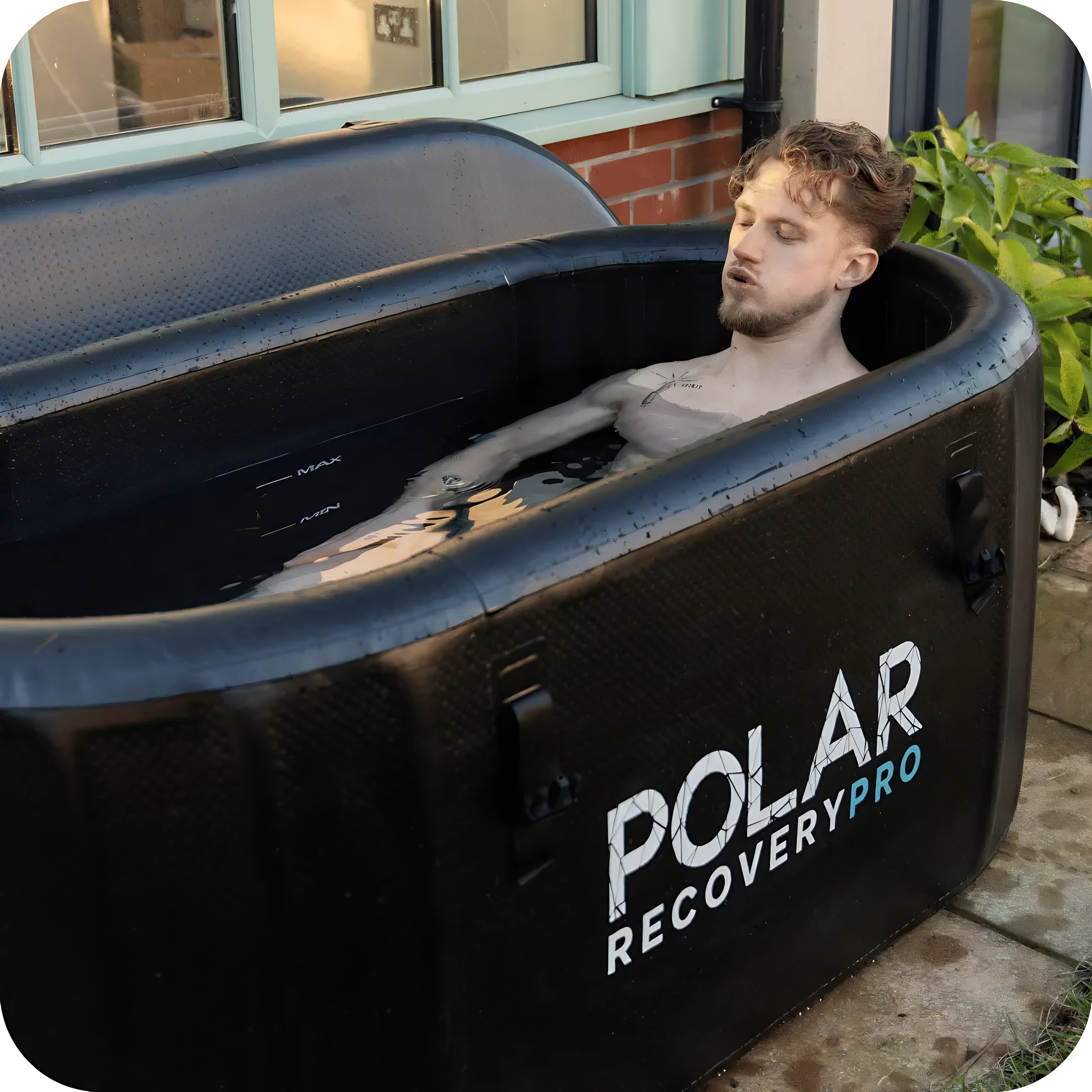 Polar Recovery Pro inflatable ice bath in black, man lying back in water