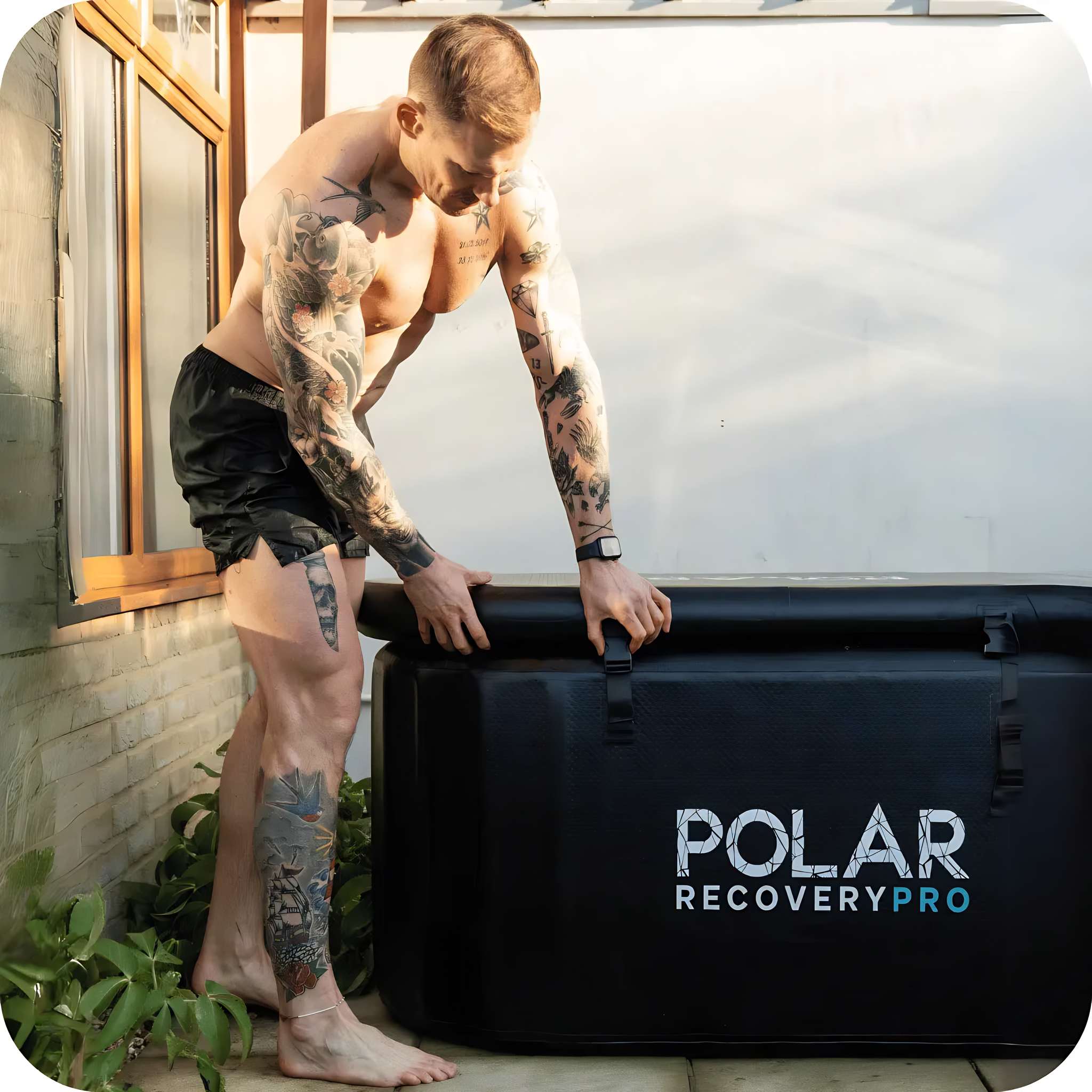 Polar Recovery Pro inflatable ice bath in black, tattooed man climbing in