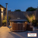Polar Recovery Royal round wood fired hot tub with dimensions, on a patio at dusk
