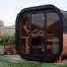 Polar Recovery Sauna Cube 3-5 person outdoor sauna with glass front, woman reading inside