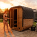 Polar Recovery Sauna Cube 3-5 person outdoor sauna, woman opening the door at sunset